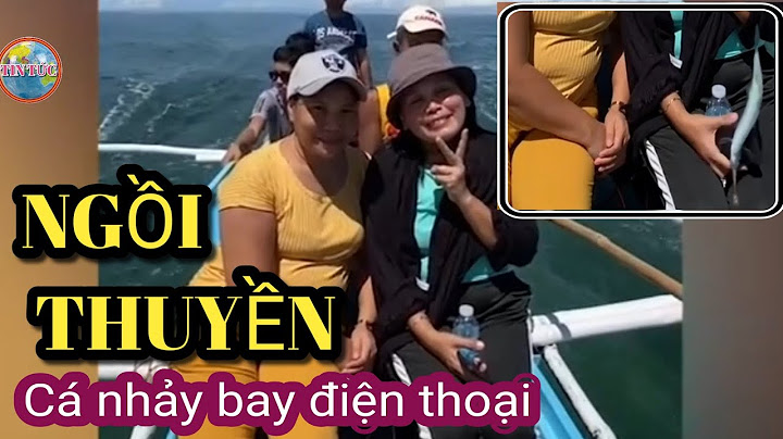 Đang ngồi trên thuyền chụp ảnh cùng bạn cô gái cầm điện thoại trên tay bất ngờ bị văng xuống biển.