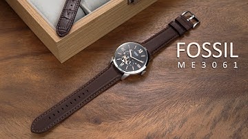 Review đồng hồ Fossil ME3061 kim chỉ và vạch chữ số la mã nổi bật trên nền đen.