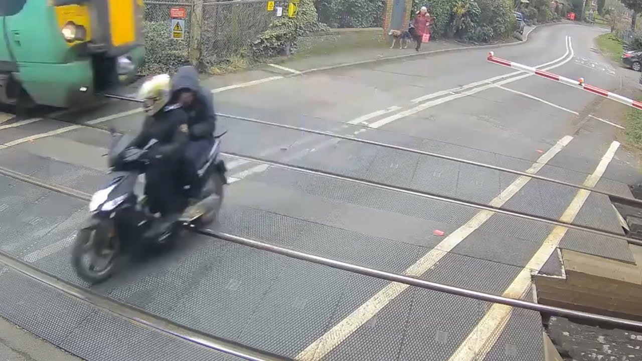 Moped riders nearly struck by train after running red light in England ...