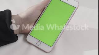 Hand Holding Touch Green Screen Smart Phone On White Background. Stock Footage. Hand Tapping On A