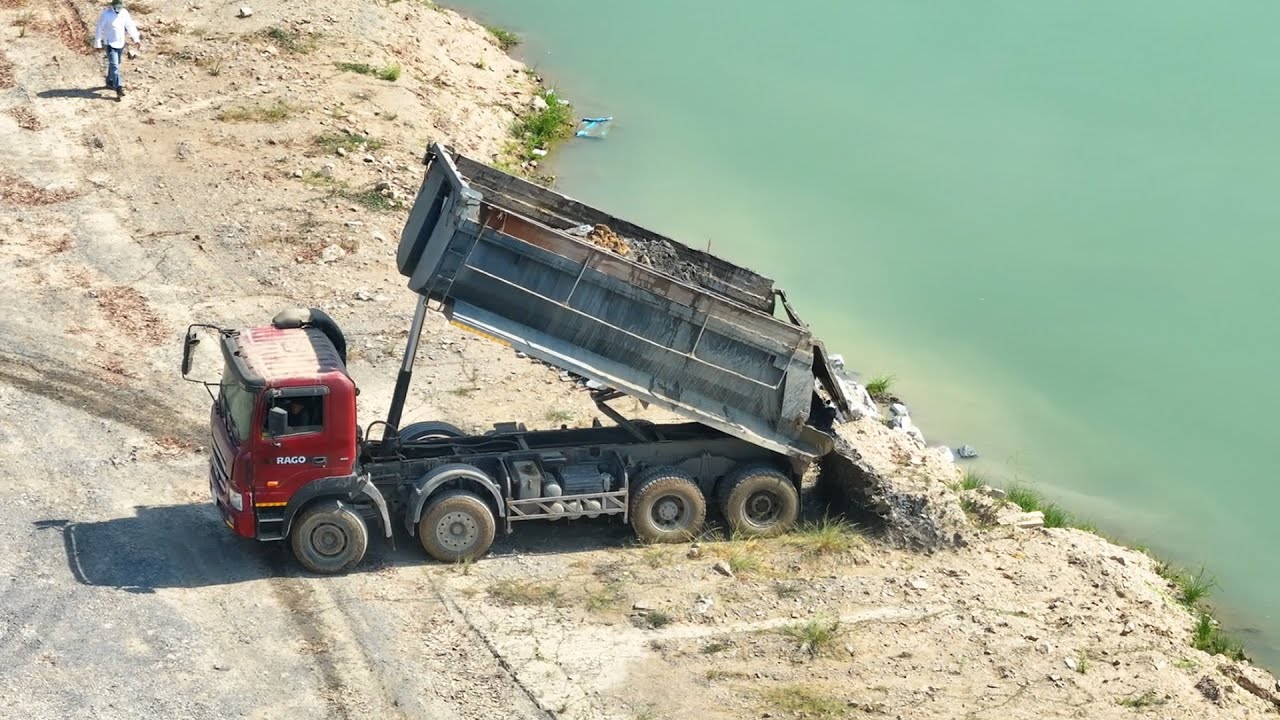 New road paving project with a small bulldozer and a 25 ton truck carrying paving stones