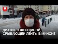 Женщина срывает белые и красные ленты в Грушевке днем 11 февраля