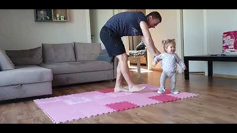 Toddler Girl Does Stretching Exercises at Home With Dad