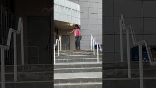 Girl riding roller skates does multiple jumps down stairs then fall and lands on rear on steps