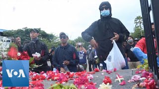 Fans Sepak Bola Indonesia Melempar Kelopak Bunga Sebagai Penghormatan Kepada Korban Kerusuhan Maut