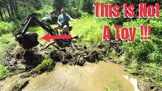 Red Rock Mini Backhoe being put to work digging a drainage ditch