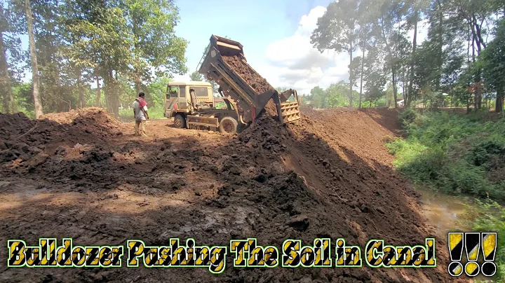Truck work with pond ! bulldozer pushing the soil into water in forest ! Mitsubishi bd2f skill