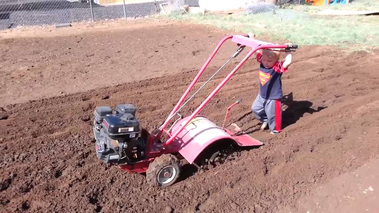 Kid running a Rototiller for our 2014 Garden 