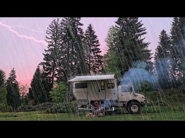 CAMPING WITH A UNIMOG CAMPER AT A RAINY SUNSET class=