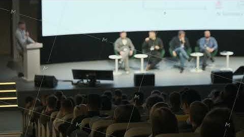 Panel discussion at conference stage with speakers and audience