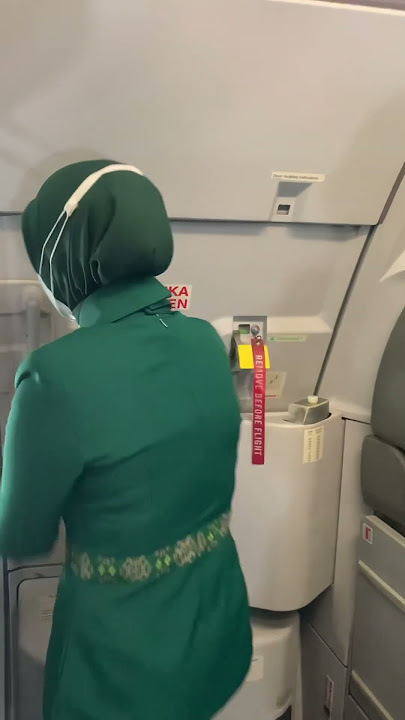 Pramugari berhijab Citilink sedang membuka pintu pesawat di Bandara Internasional Silangit