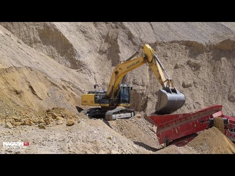 NEW HOLLAND KOBELCO E305C excavator loading  TEREX Finlay 883+ screening machine