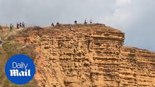 Shocking moment tourists get close to 150ft drop off Dorset cliff Shocking moment tourists get close to 150ft drop off Dorset cliff