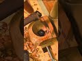carving a deep round hole inside a wooden block using a curved hand gouge chisel tool closely