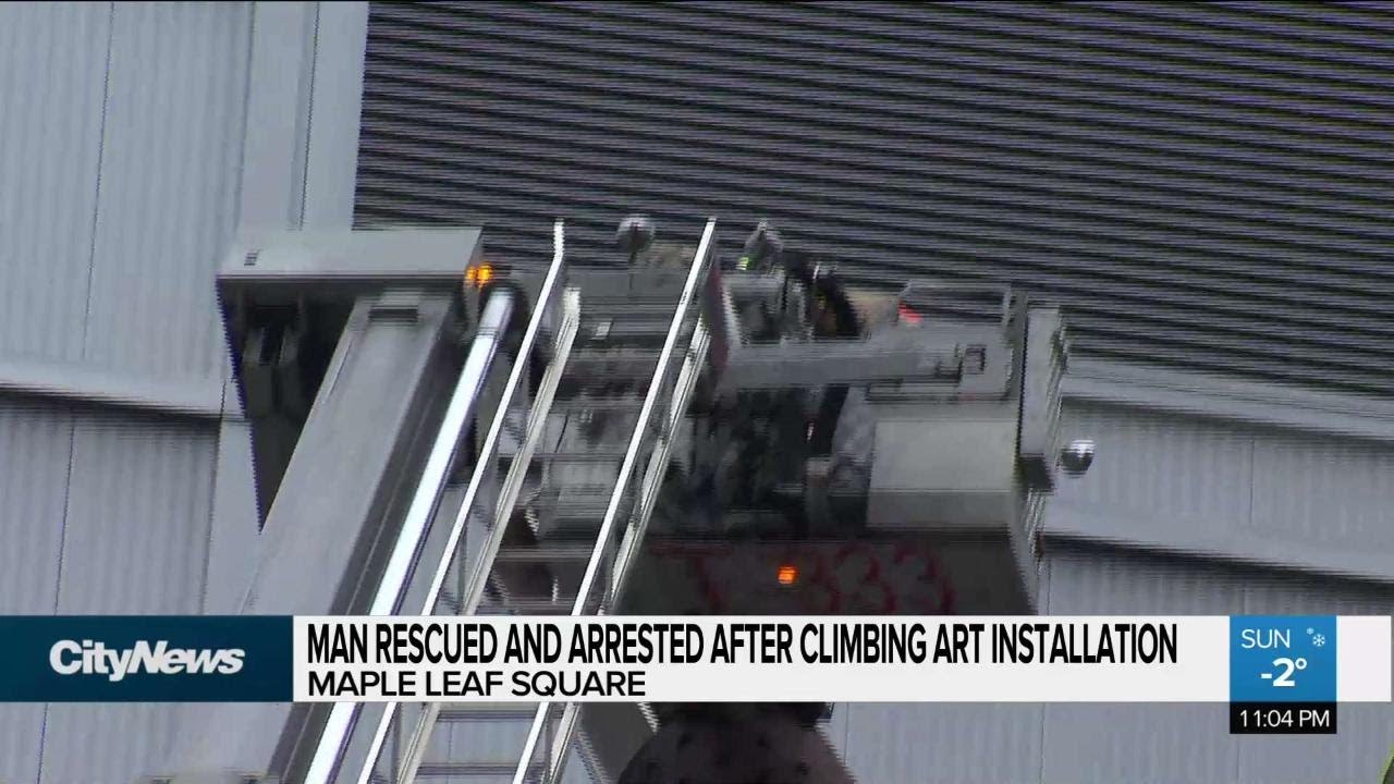 Man rescued and arrested after climbing art installation - YouTube