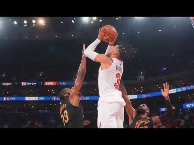 A basketbal player from NY Knicks shooting on the basket is in the picture