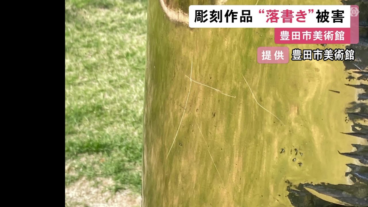 A sculpture exhibited outdoors at a museum has graffiti-like