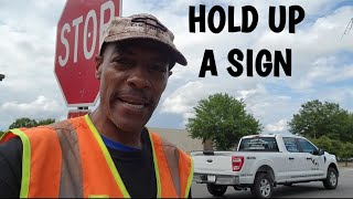 GET OUT ON A INTERSECTION AND HOLD UP YOUR SIGN