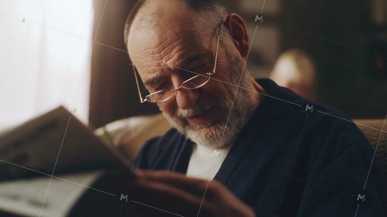 Grandfather reading a newspaper on sofa