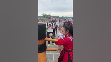 红衣少女在长城边演示武术，木人桩上的拳脚生风，游客纷纷驻足拍摄，文化的魅力在此刻绽放！ #huangyanmartialarts #kungfu #martialarts