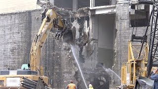 Demolition excavator demolishing part of a concrete (and steel) building