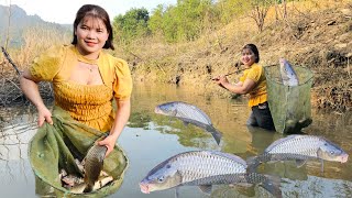 When the lake water receded, the girl used a net to block the stream to block the fish.