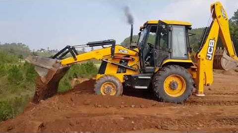 Jcb backhoe loader dozing and levelling the field