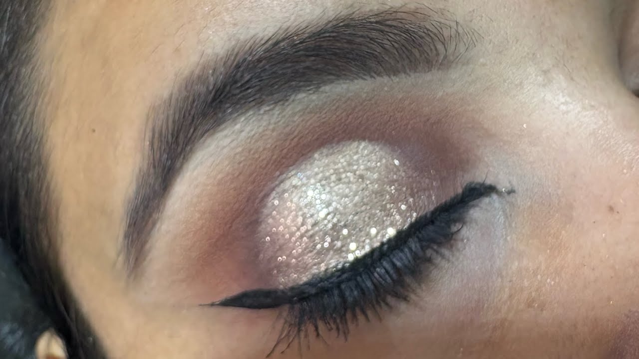Graphic Halo eye makeup with golden glitter 