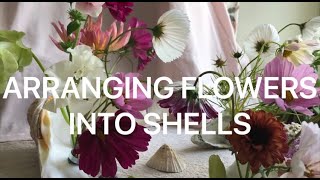 Arranging flowers in pin holders in shells