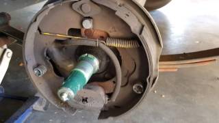 Inspecting the trailer brake assembly.