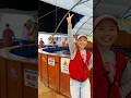 女性スタッフの後ろでナマズを釣る動画
