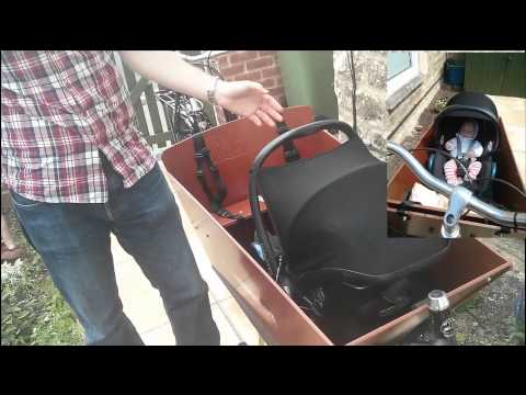 Carrying an infant in a Bakfiets using maxi cosi and rain tent