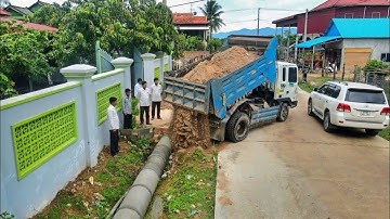 Dropping soil to bury drainage next to the concrete roads and clearing trash behind the house