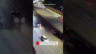 A person had to jump onto a road divider to avoid being hit by a vehicle while on a highway.