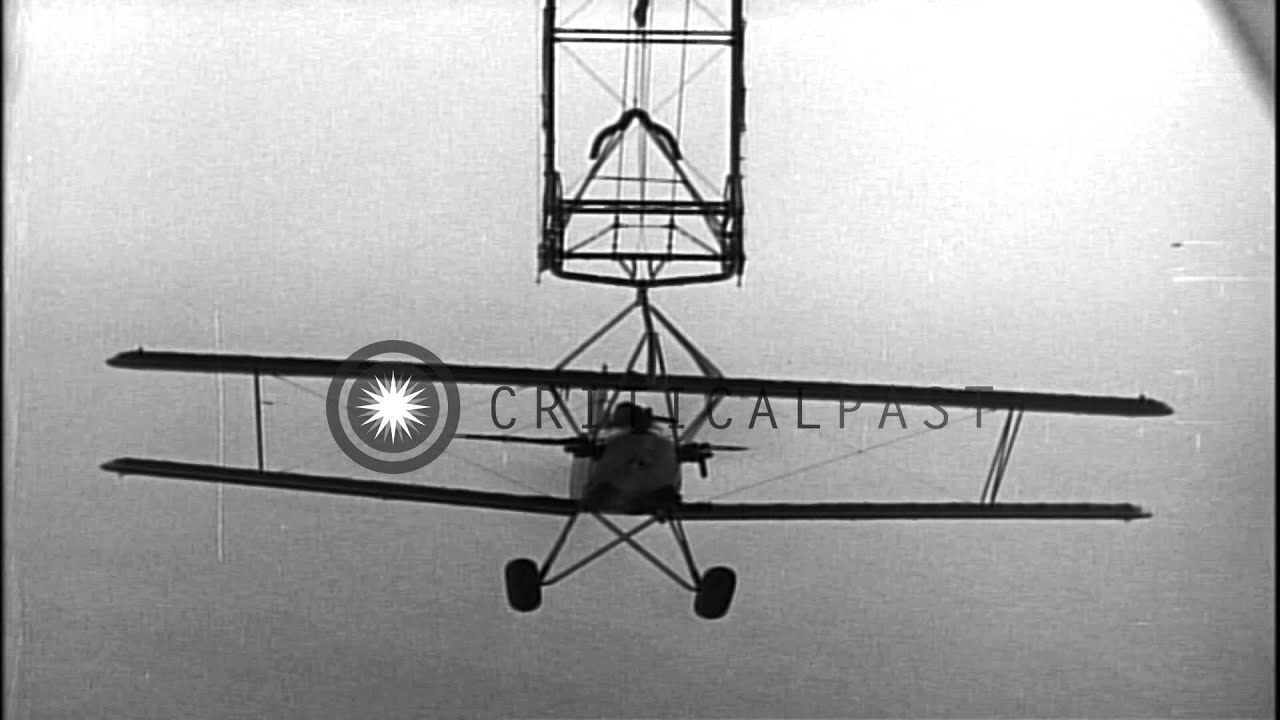 N2Y Biplane hooks onto the aircraft trapeze of USS Akron (ZRS4) dirigible at La...HD Stock