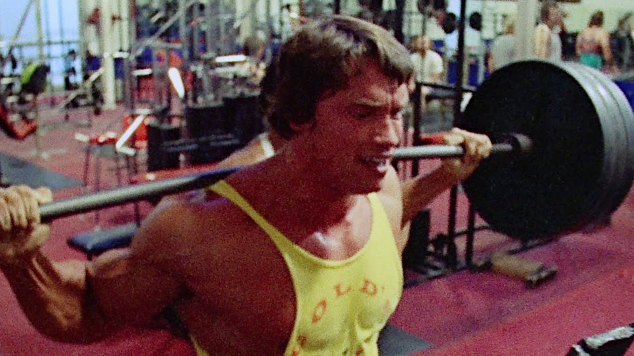 Arnold Schwarzenegger and Ed Corny train their legs by doing barbell