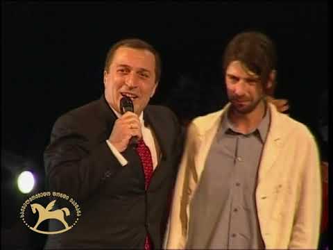 პაატა ბურჭულაძე და ილიკო სუხიშვილი სცენიდან საქართველოს კათოლიკოს-პატრიარქს ილია მეორეს ესალმებიან