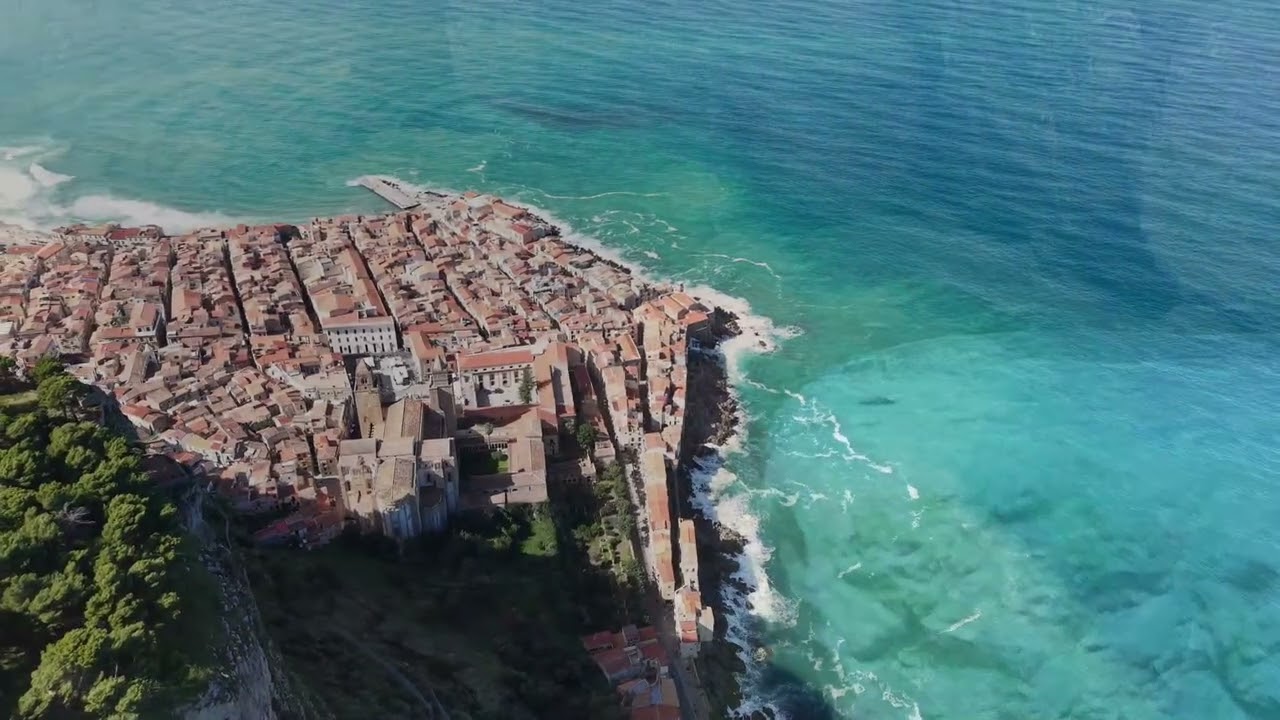 Cefalù. Sopra i tetti, la Rocca veglia: ogni sasso conserva una luce, ogni onda un canto.