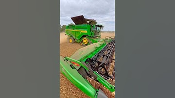John Deere X9 1100 combine harvester with 45 foot draper header working in wheat