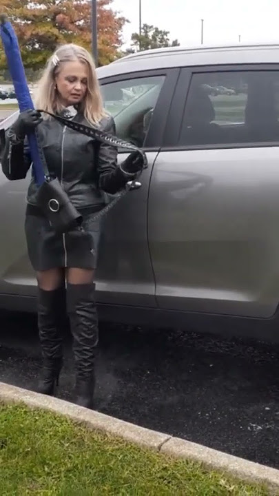 Leather Queen arrived in style. Boots, skirt, jacket, gloves, umbrella