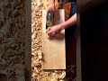 Smoothing a flat wood surface with a manual hand plane for detailed woodworking in a craft workshop