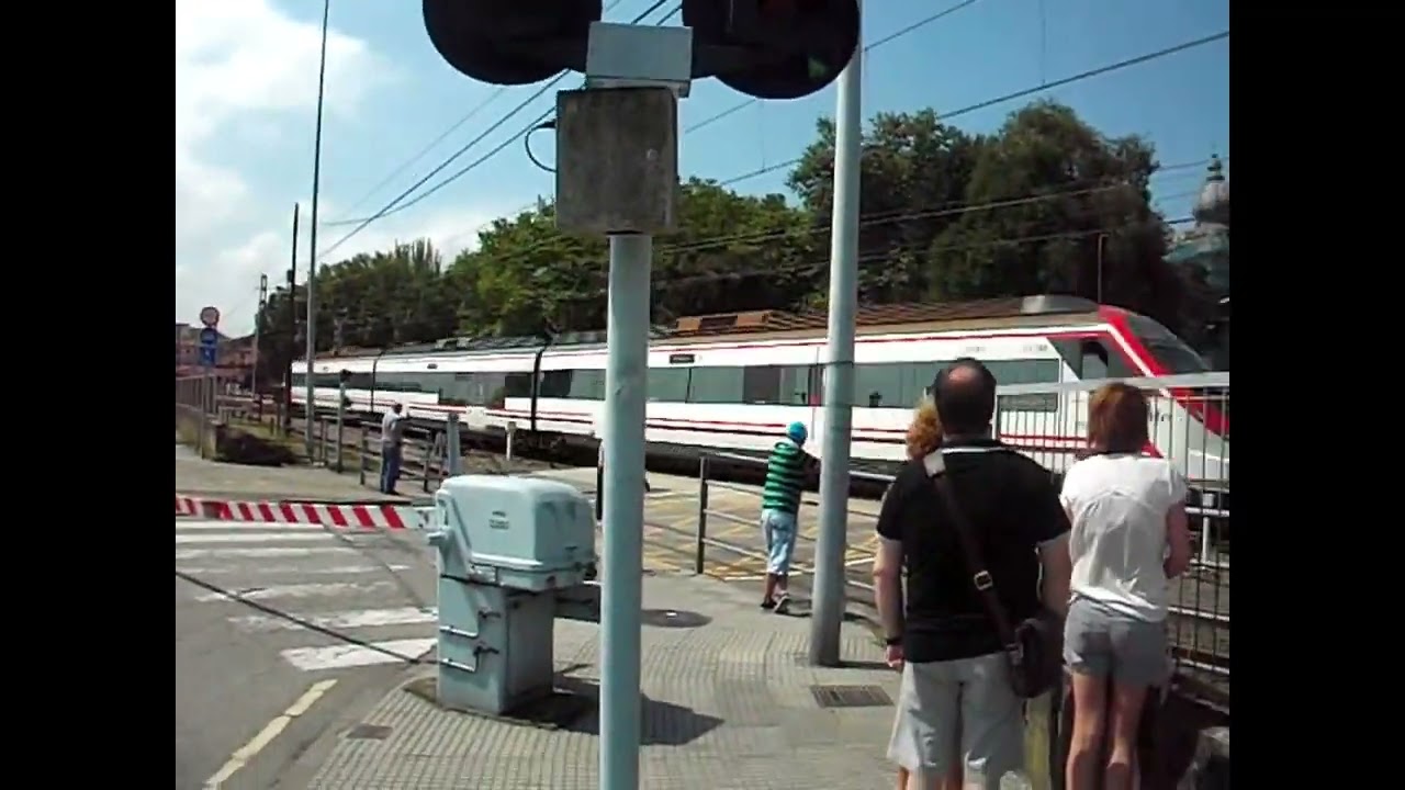 Paso de un tren de cercanías, + un tren FEVE, por el paso a nivel de Avilés.
