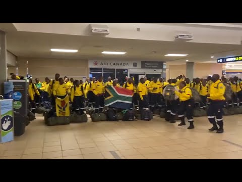 South African firefighters sing and dance after arriving at Edmonton's airport