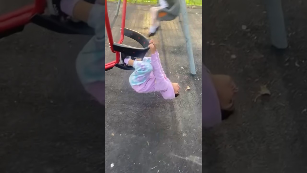 Baby hanging upside down on the Swing she started swinging at the Park