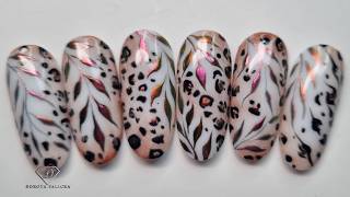 Autumn nail art with animal print and chrome leaves.