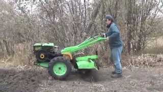 Diesel walkbehind tractor. Work cutter on solid ground.