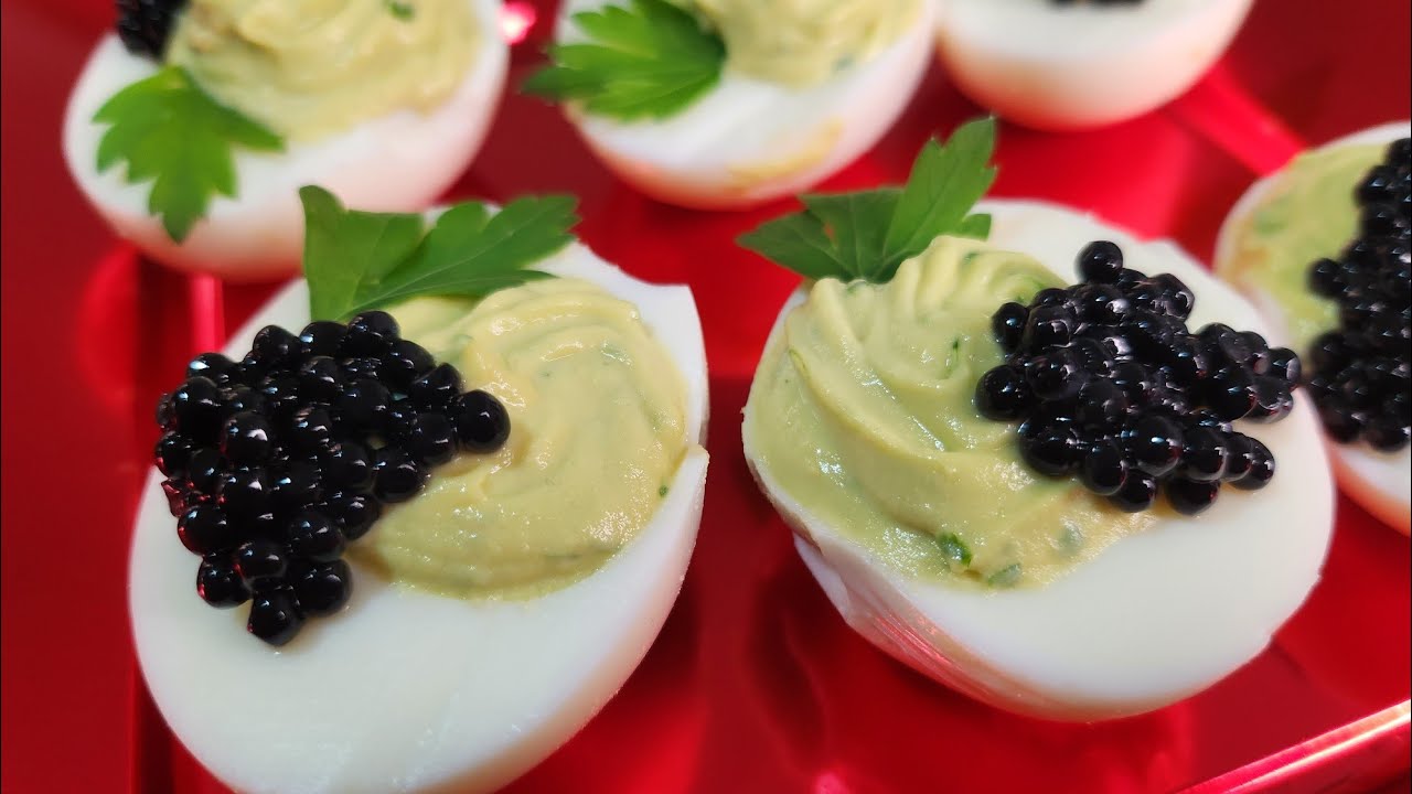 Huevos rellenos con caviar rojo y pimentón en un plato para la mesa de  pascua de aperitivo, vista superior, espacio de copia. plato tradicional  para felices fiestas de pascua.