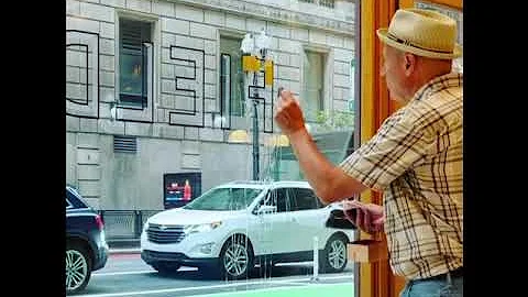 Robert W. Frese gilding a storefront window with 2...