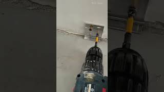 Securing a metal bracket to the lower wall base using an electric cordless screwdriver