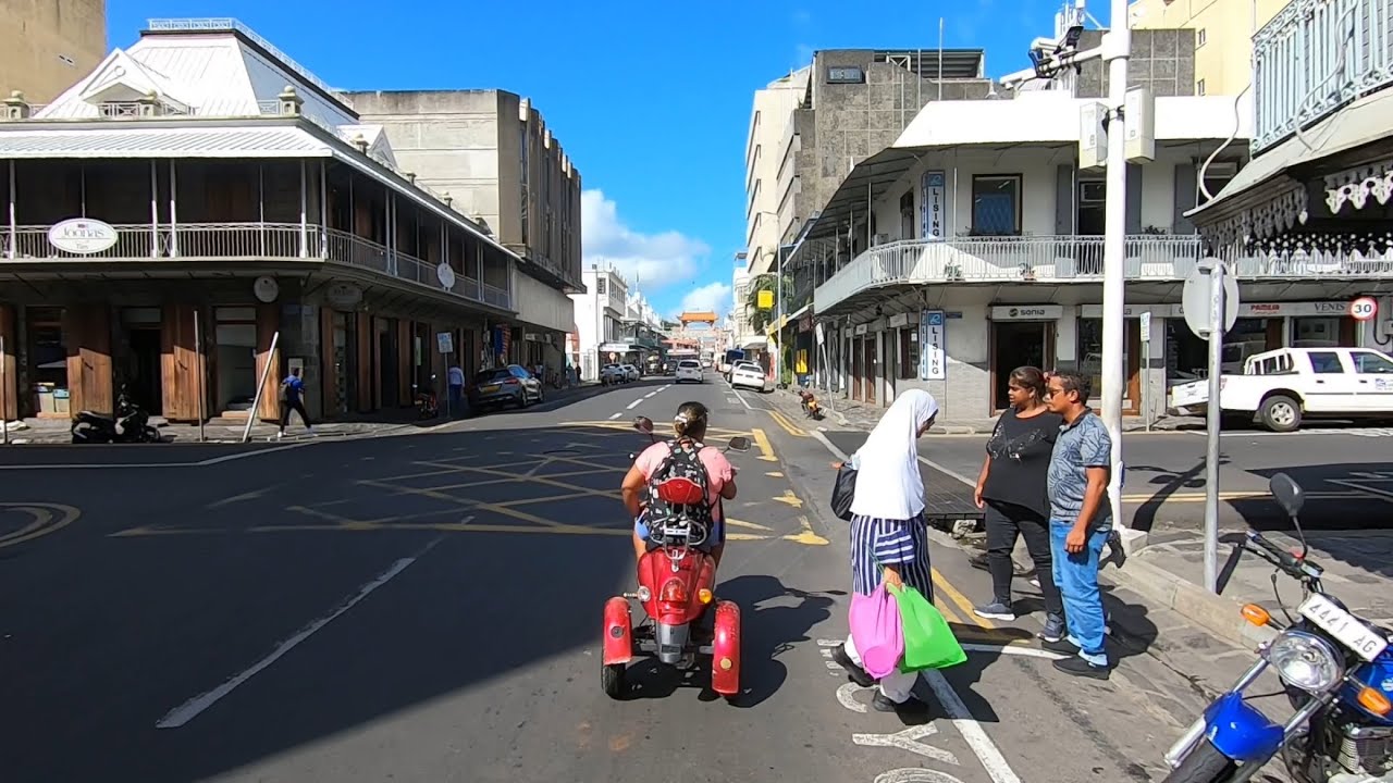 Cycling follow R2T3 around street of Port-Louis Mauritius POV